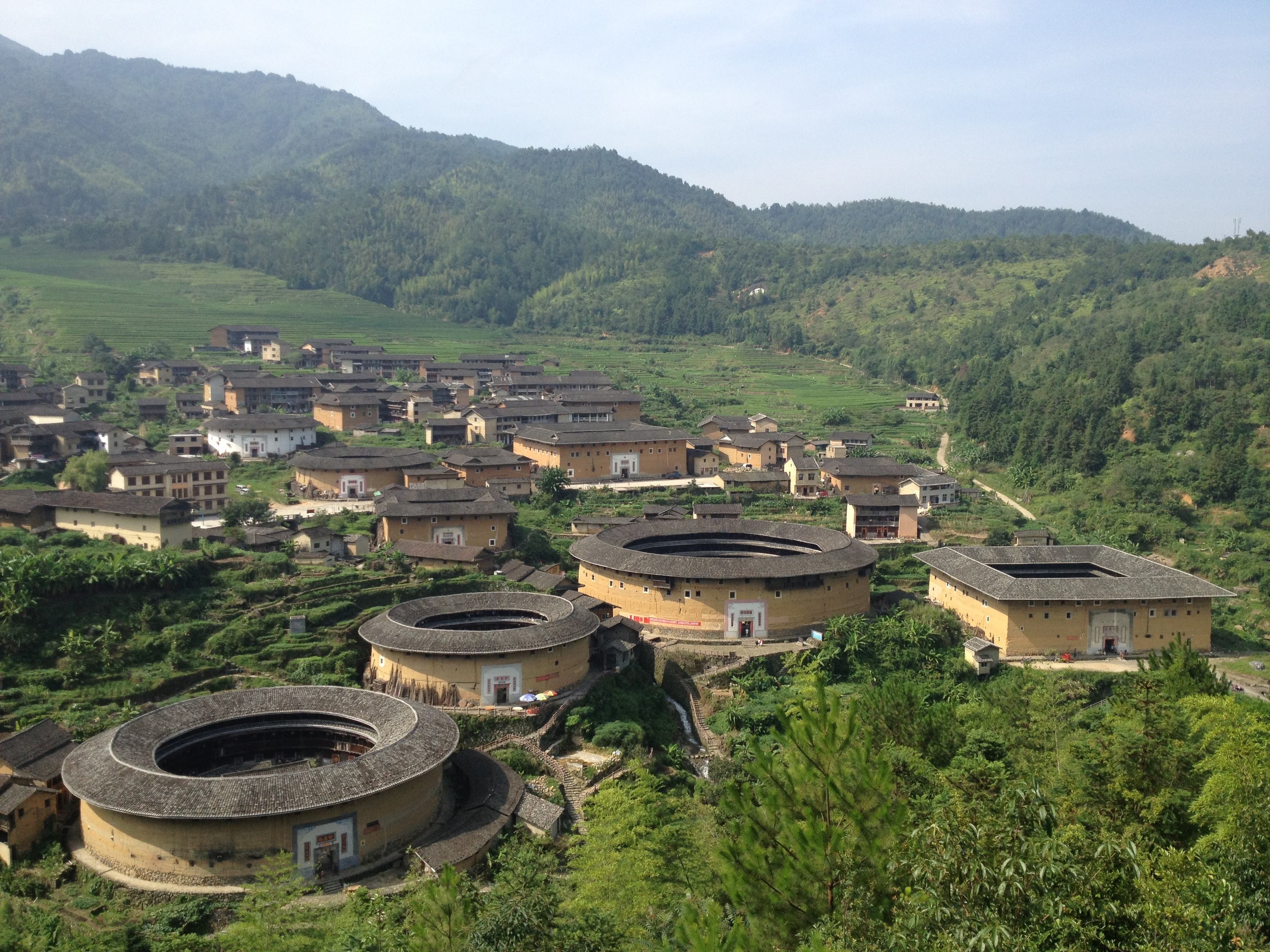 一张图片: 一段背景:图上是田螺坑土楼群,位于福建漳州市南靖县西部